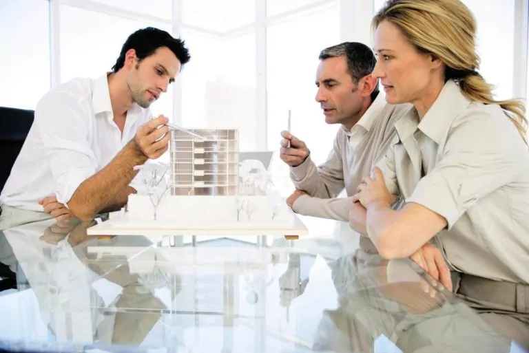 Planung eines neuen Bauprojekts Architekten diskutieren über ein Gebäudemodell