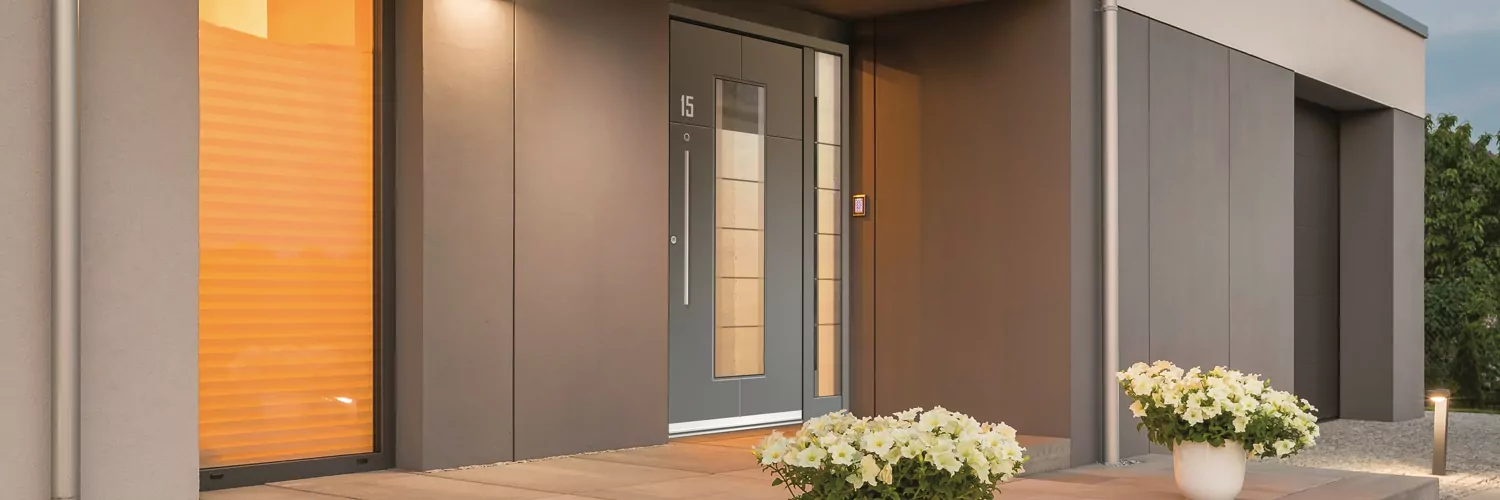 Graue Haustür an brauner Wand