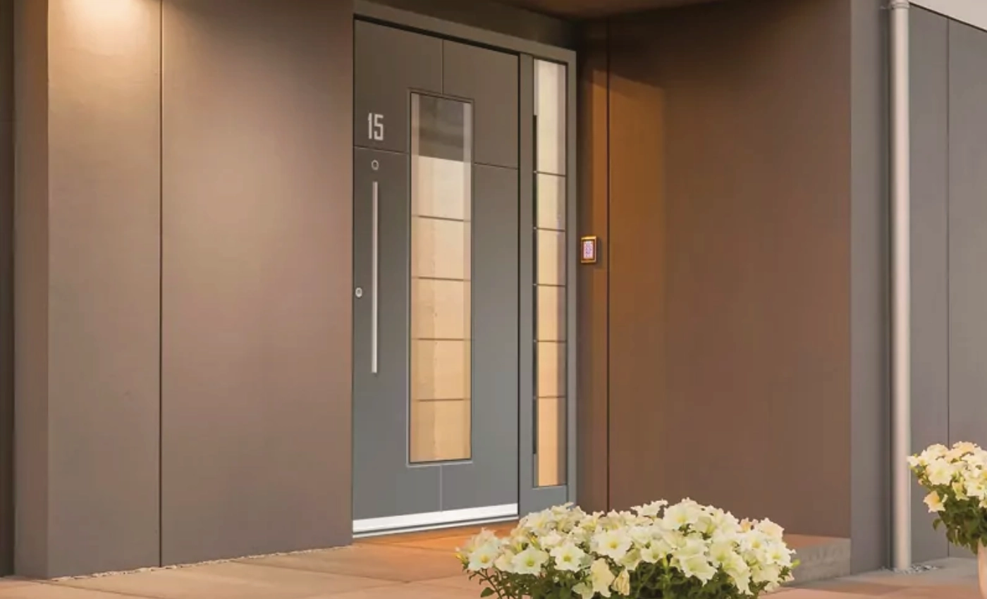 Graue Haustür an brauner Wand