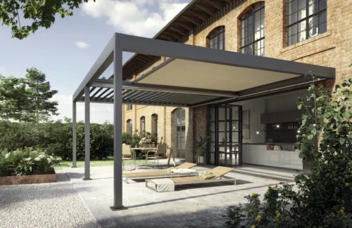 Modernes Terrassendach vor Backsteingebäude mit Gartenmöbeln und Pflanzen