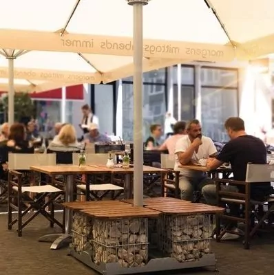 Menschen in Restaurant sitzen unter Gastroschirm Caravita Multicube